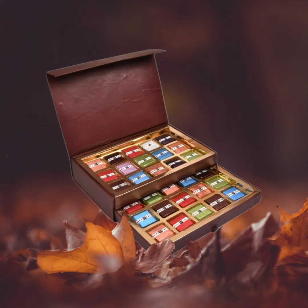 Brown leather chocolate gift box with dual drawer compartments displaying colorful wrapped chocolates