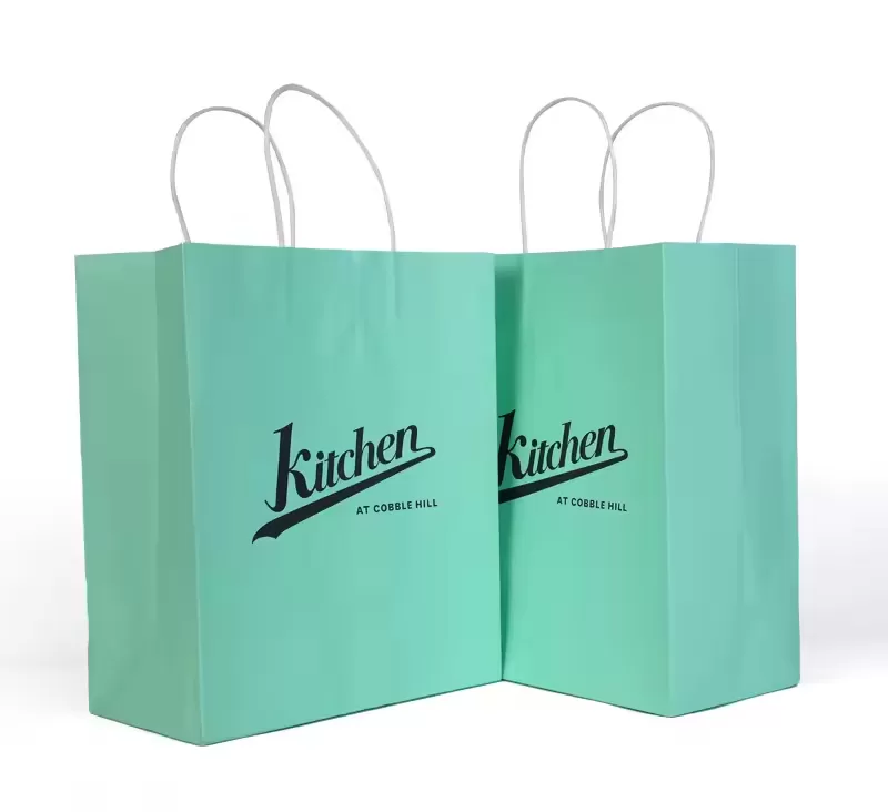 Custom printed kraft paper food bags with twisted rope handles by UGI Packaging