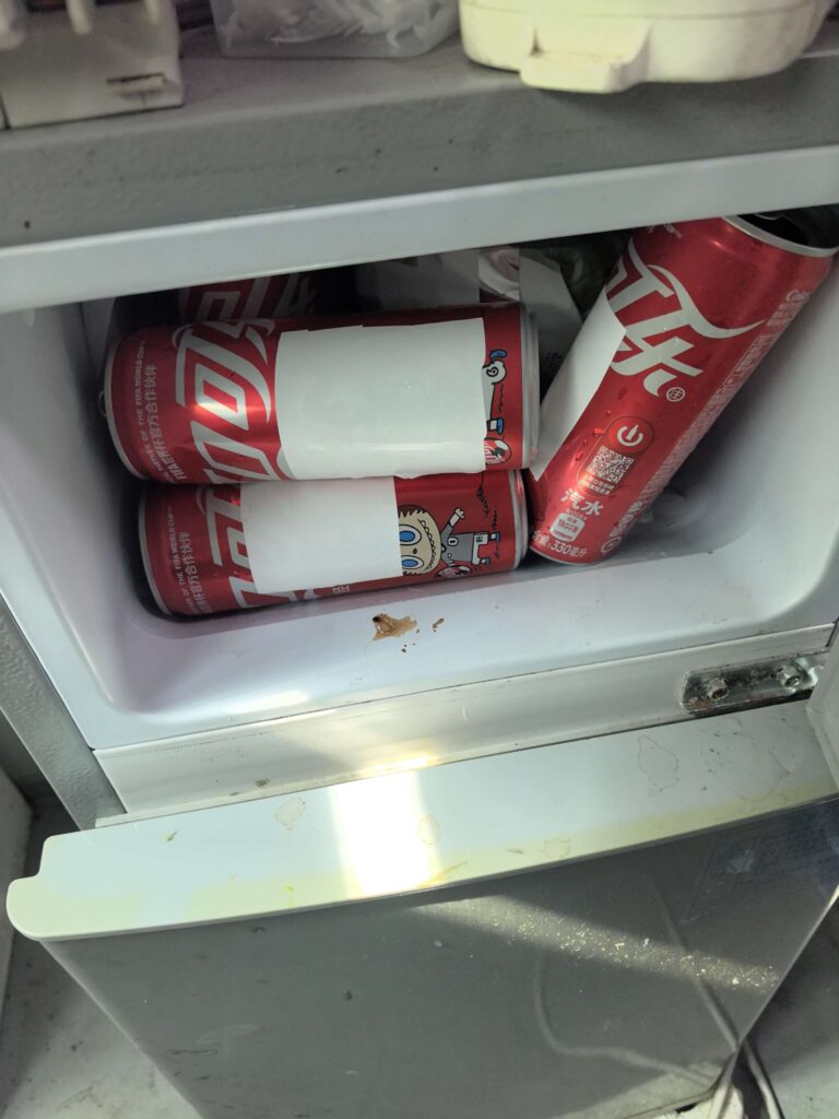 White freezer-grade label samples applied to beverage cans during refrigerated observation